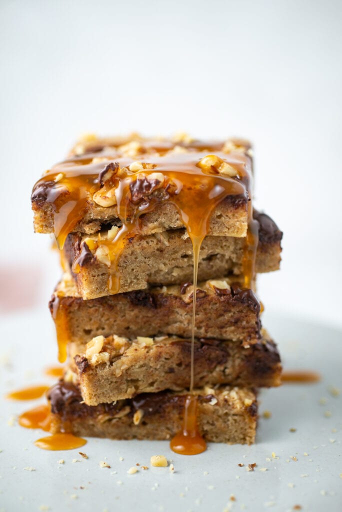 Banana Chocolate Chip Bars stacked with caramel drizzling off the edges