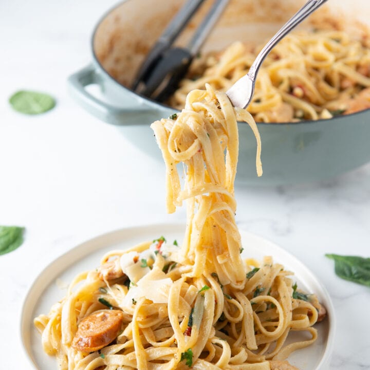 Creamy Cajun Chicken Pasta on a white plate with a twirl of pasta on a fork