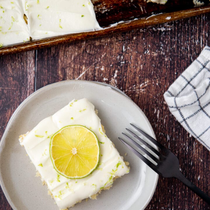 Close-up shot of a piece of Key Lime Sheet Cake on a plate with a fork